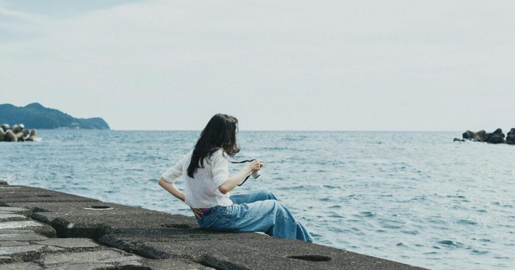 静岡の海をみている女性の画像